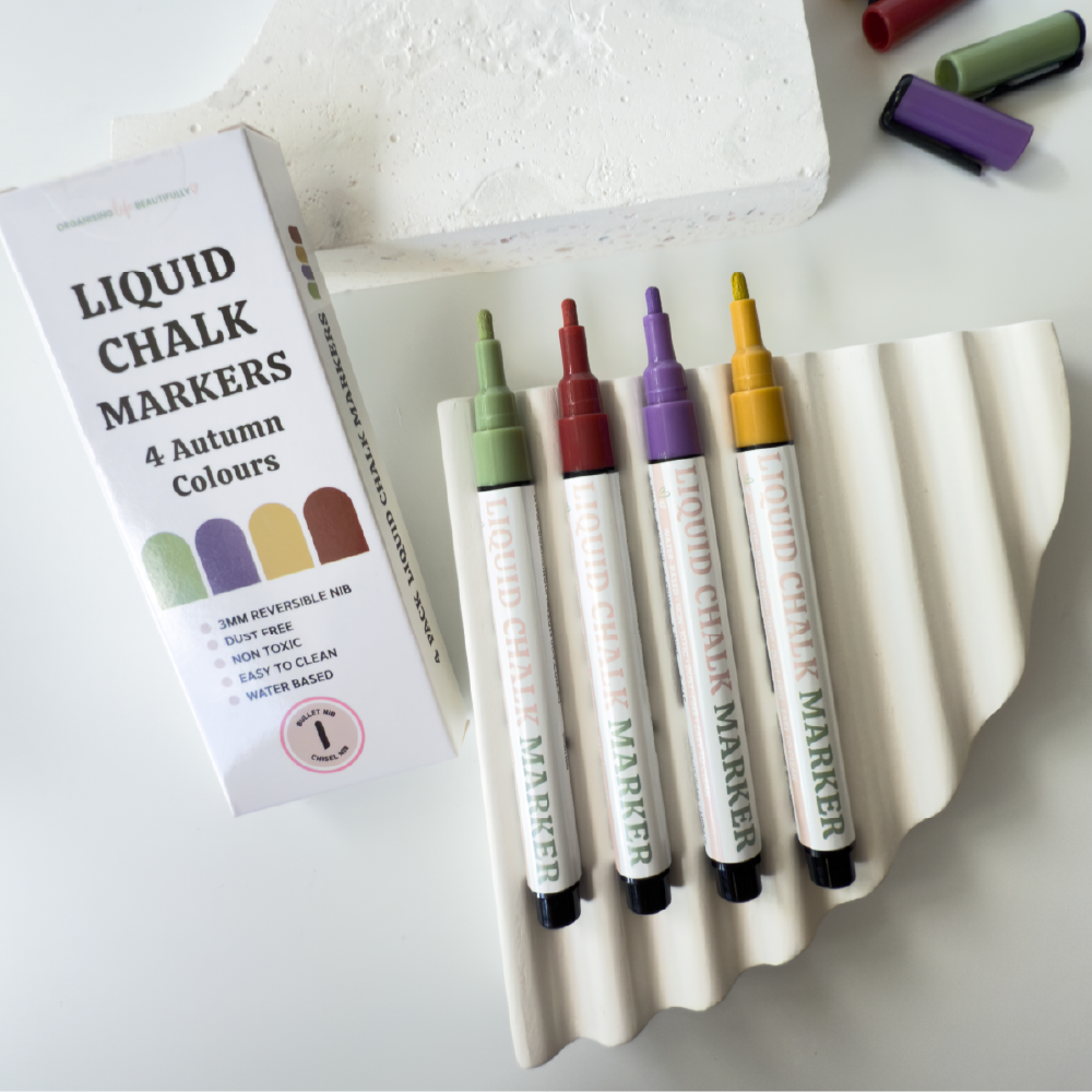 Coloured liquid chalk markers in red yellow purple and green with exposed nibs